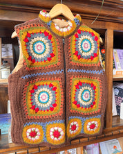 A handmade crochet vest with a colorful granny square pattern.