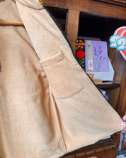 A close-up of a tan fleece zip-up vest interior, showing the soft texture and a side pocket.