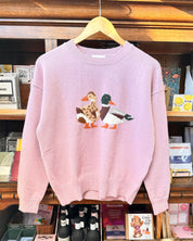 A light lavender sweater featuring a male and female mallard duck.