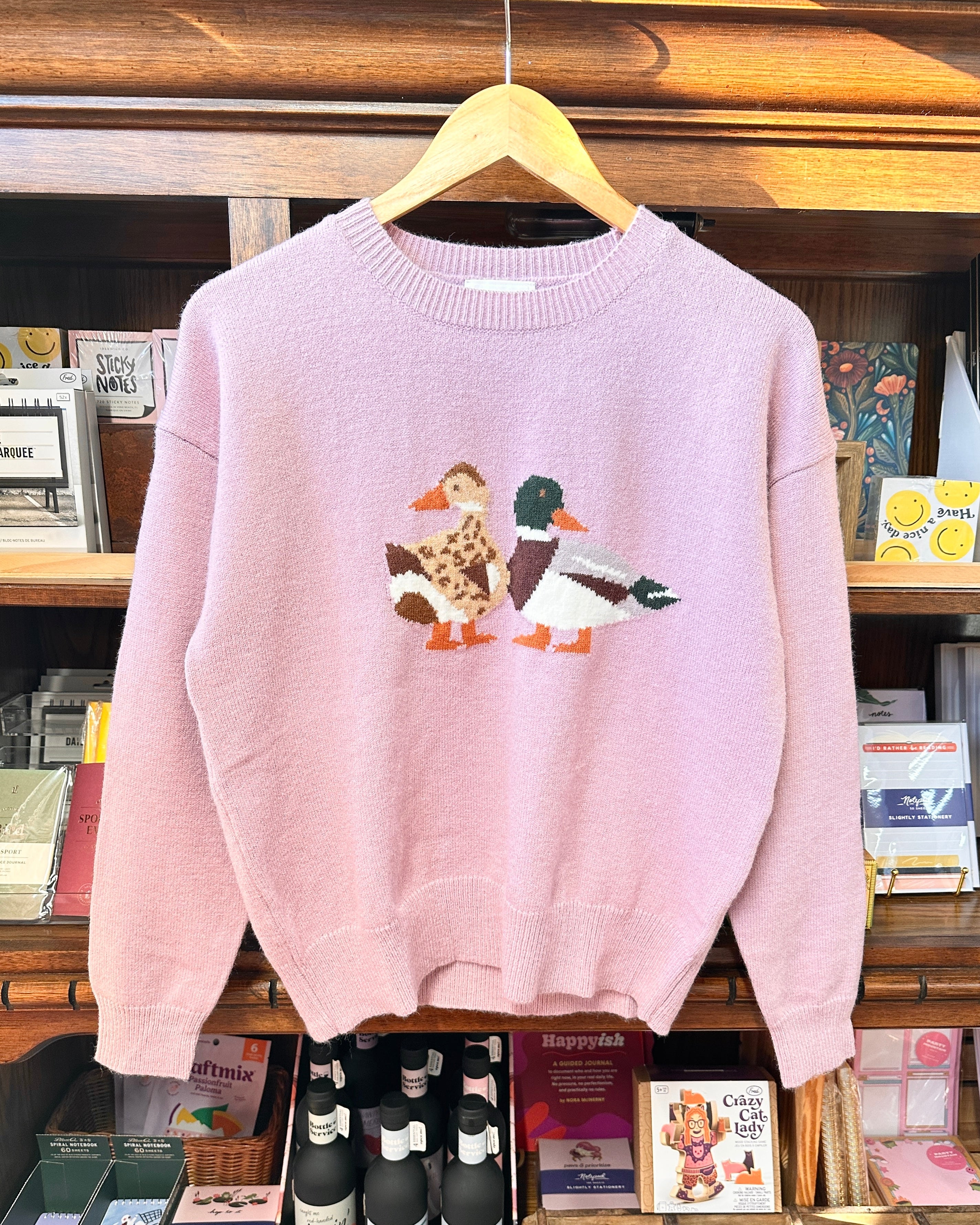 A light lavender sweater featuring a male and female mallard duck.