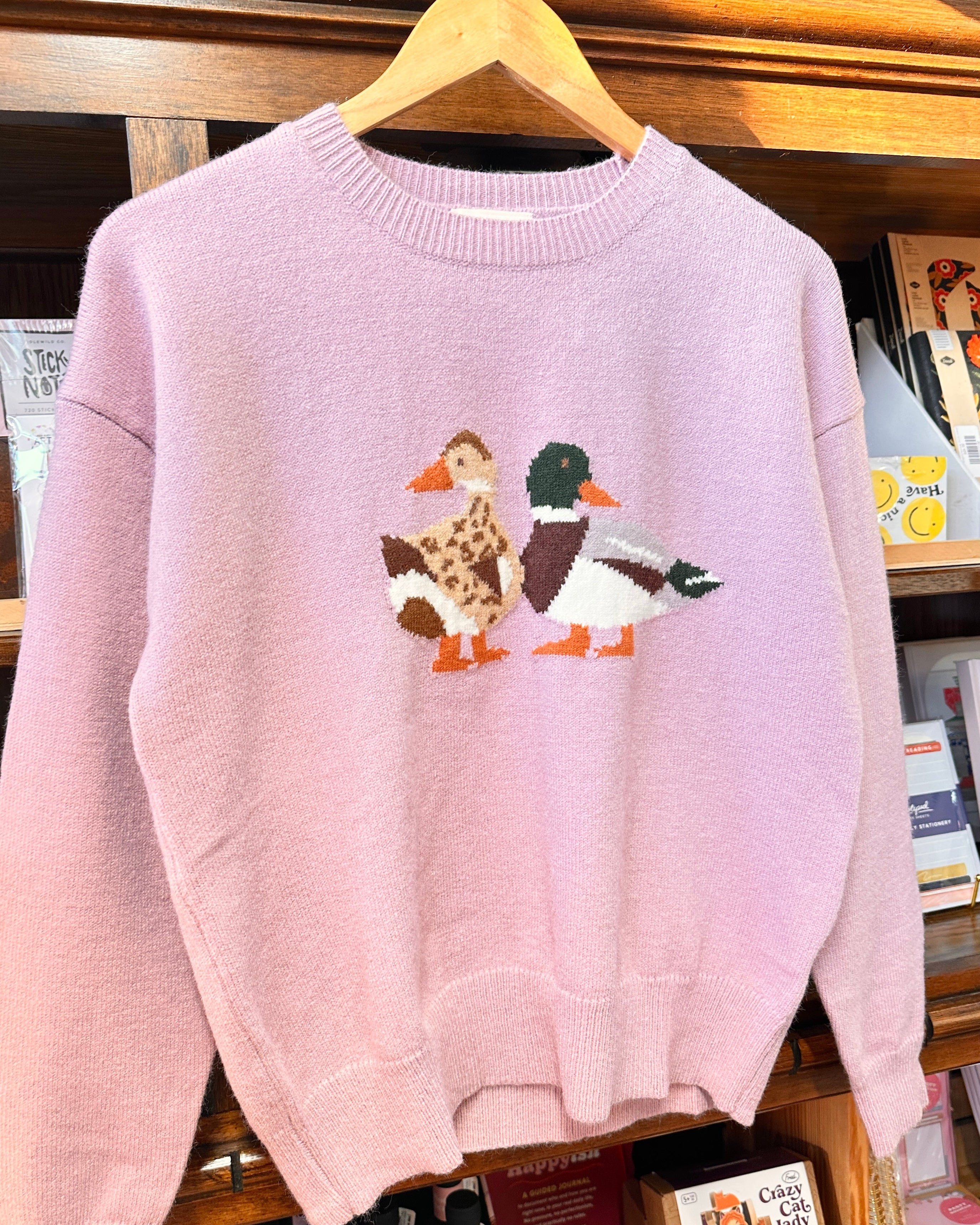 A light lavender sweater featuring a male and female mallard duck.